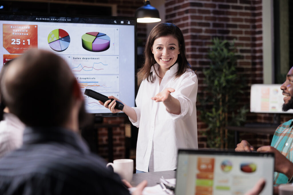 A woman gives a presentation, owning her space in a business setting, breaking the habit of overapologizing